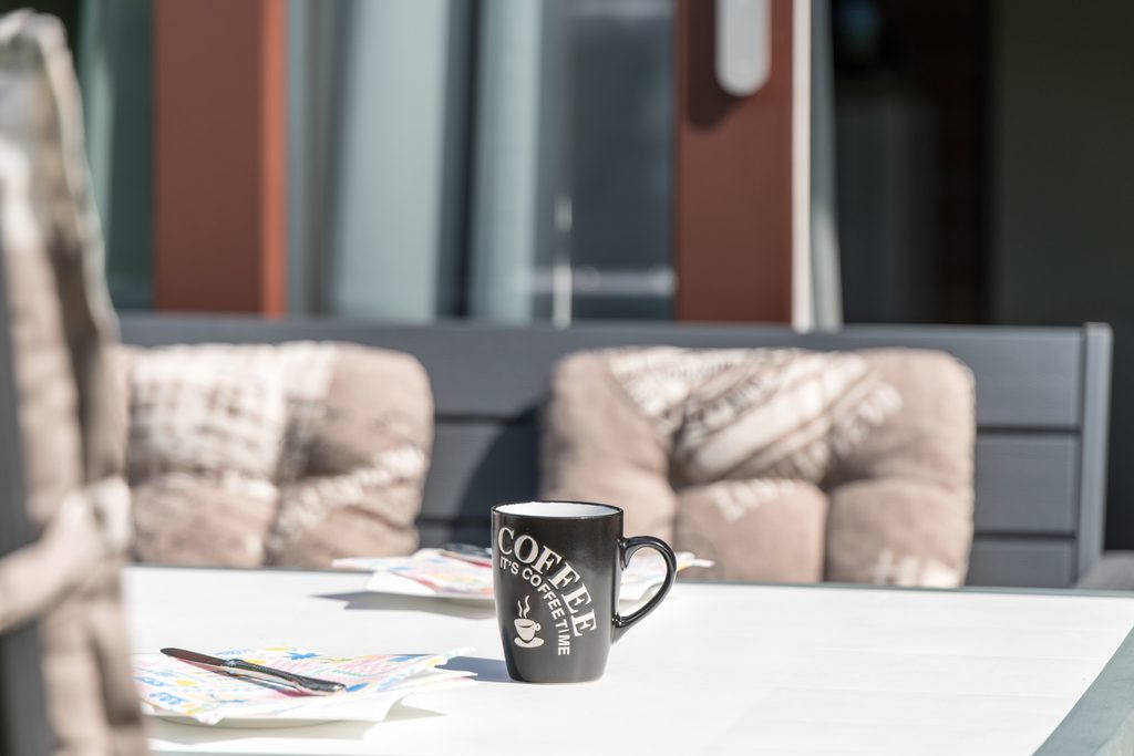 Kaffeetasse auf dem Terrassentisch in der Sonne